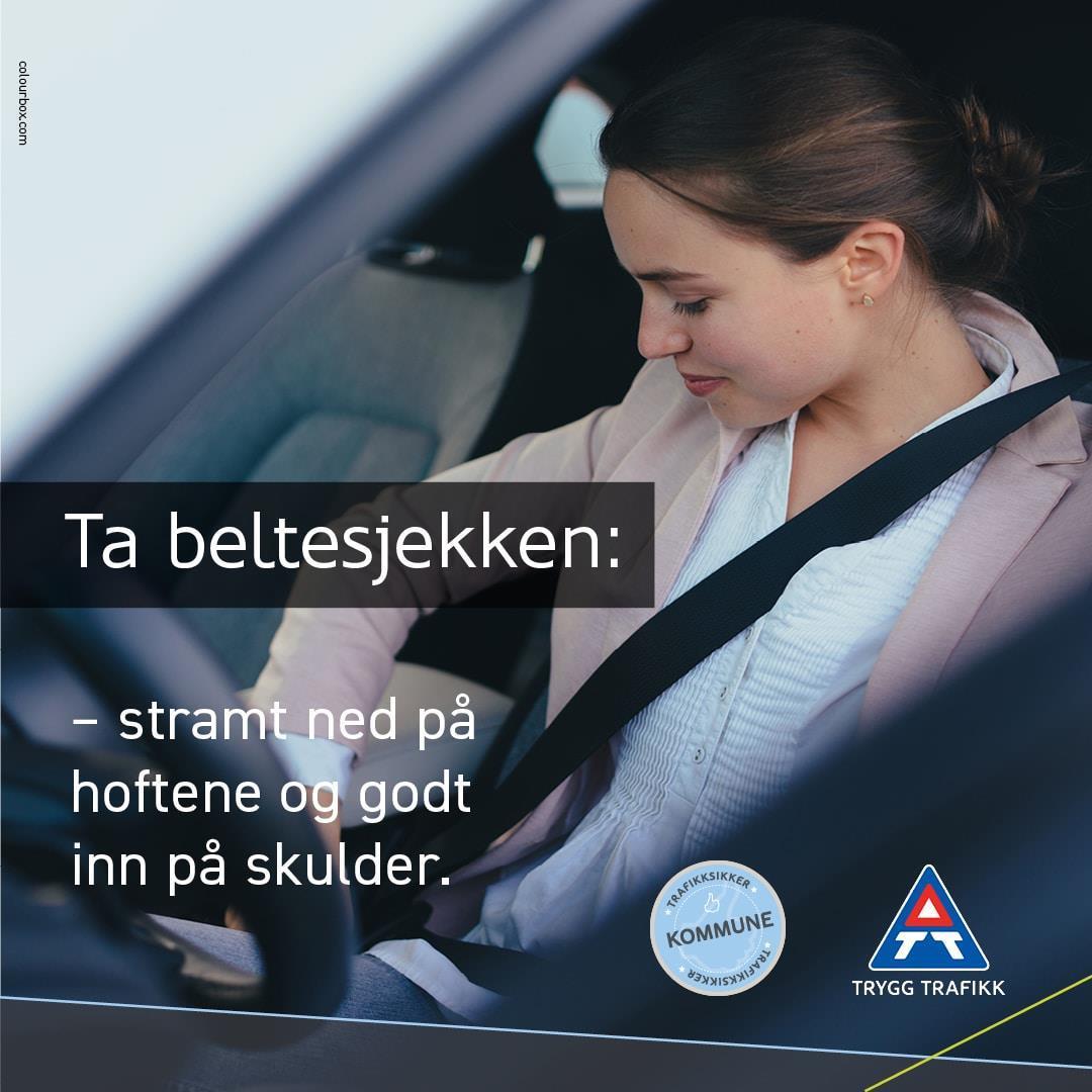 Kvinne som sitter i førersetet på en bil og sjekker at bilbeltet er riktig festet. - Klikk for stort bilde