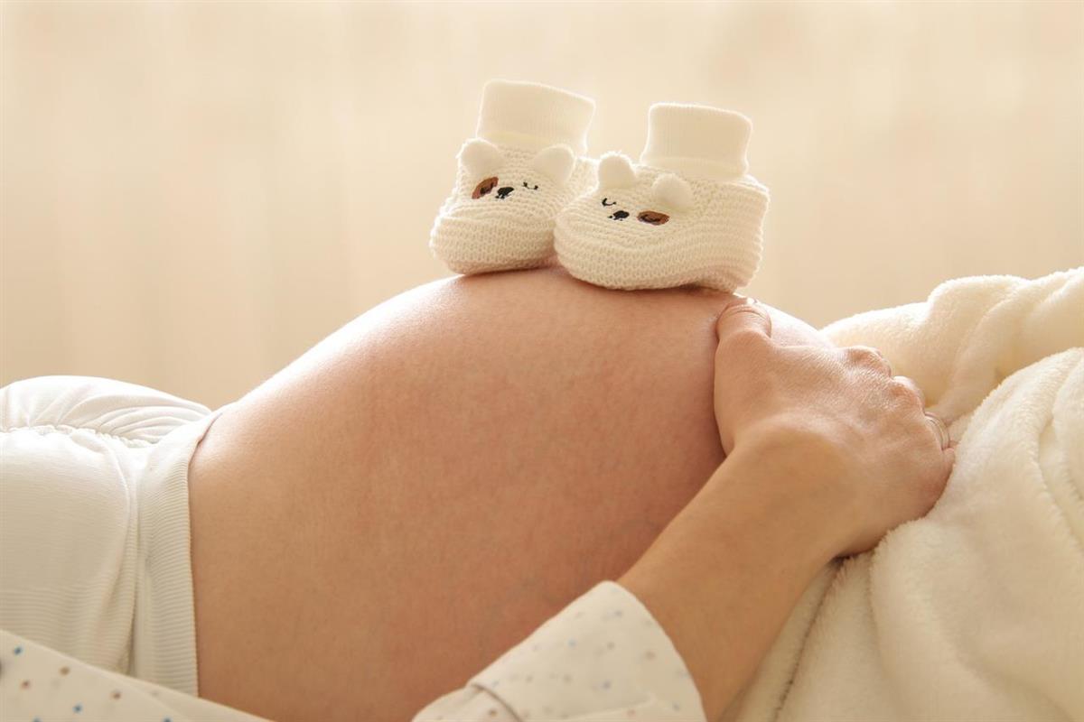 Mage på gravid kvinne. Fottøy for barn. - Klikk for stort bilde