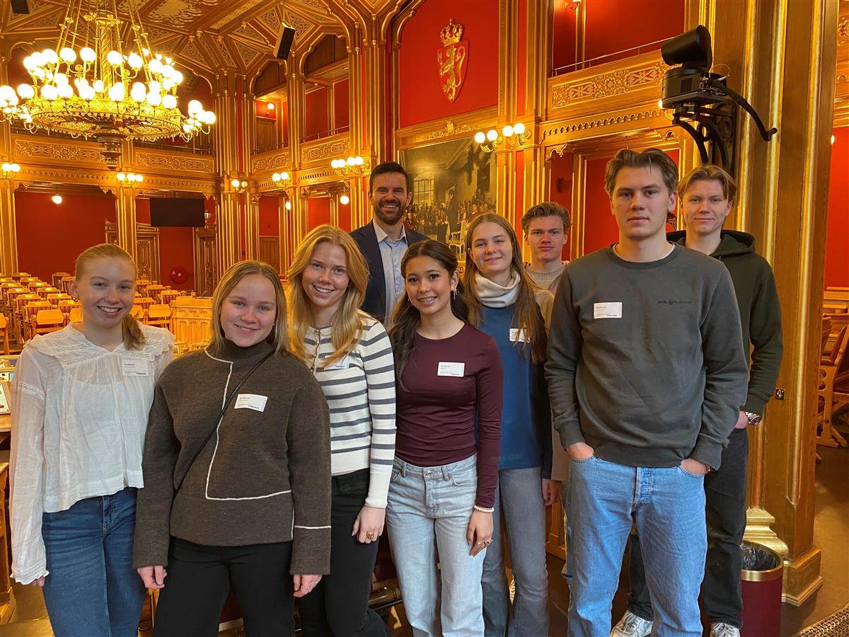 Ni personer stående inne på Stortinget - Klikk for stort bilde